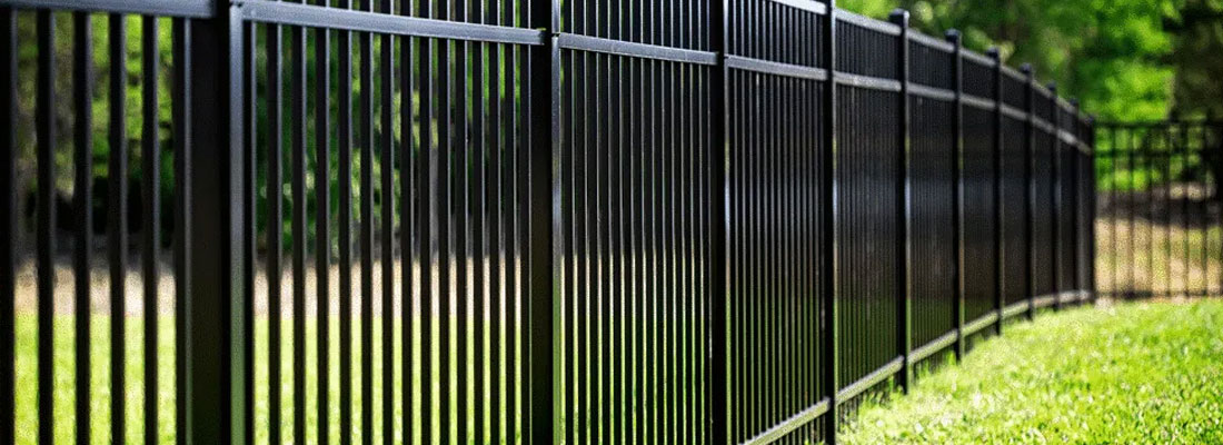 Close-up of black aluminum fence pickets and rails