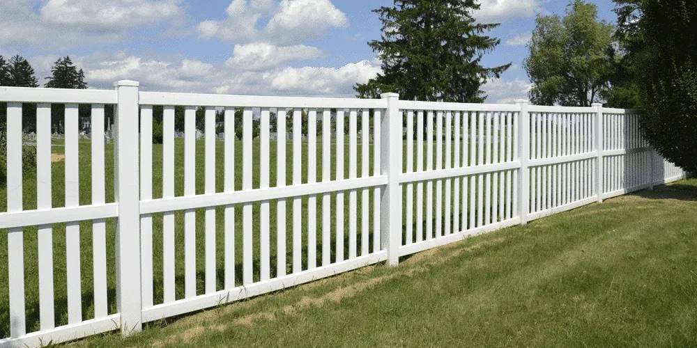 White Commercial vinyl fence erected on grass