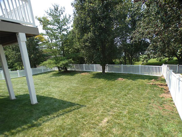 White vinyl spaced picket fence across a back yard in Imperial, MO