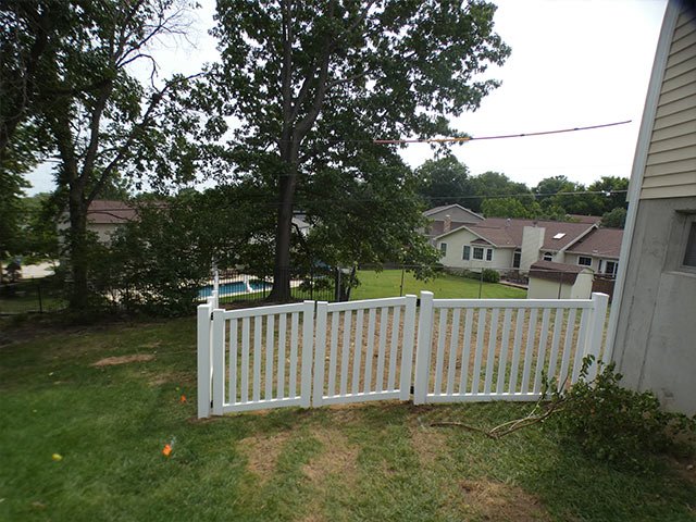 White vinyl picket fence around a corner lot yard in Fenton, MO