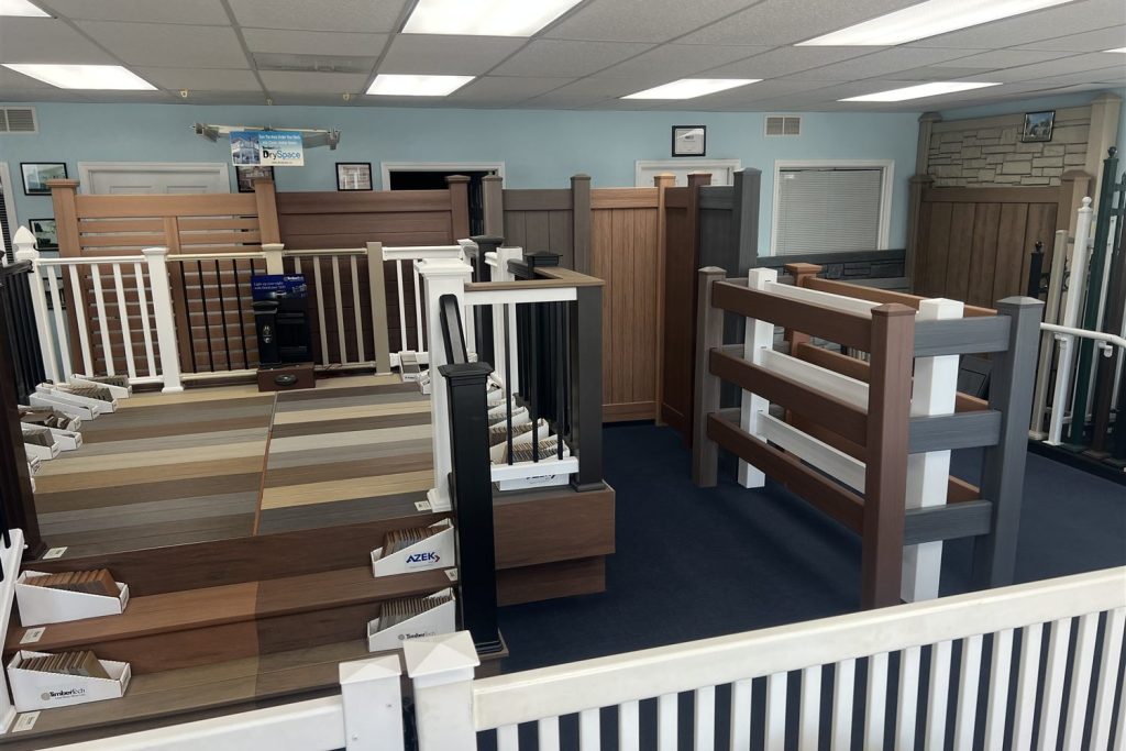 Post-and-rail fence display beside wood-look panels in the Arnold showroom